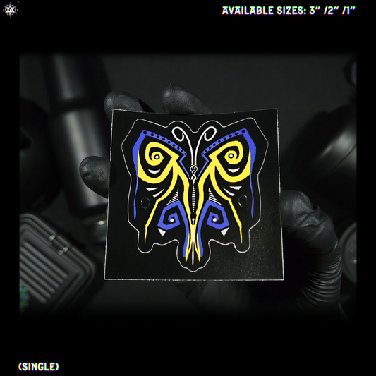 Butterfly-shaped sticker with blue, black, white and yellow design on a blurred background.