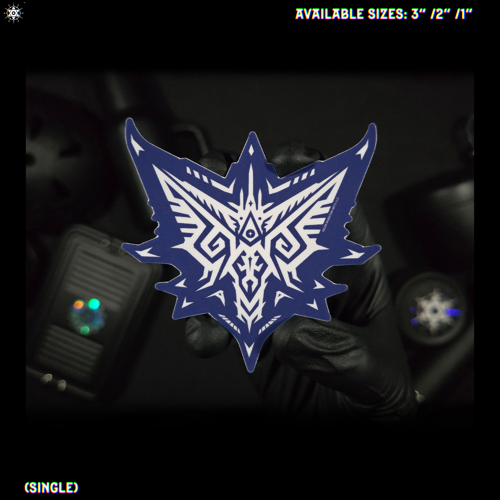 A blue and white geometric tribal-style shield-shaped sticker held by a gloved hand against a dark background, with text reading 'AVAILABLE SIZES: 3" / 2" / 1"' and '(SINGLE)' in the corners.