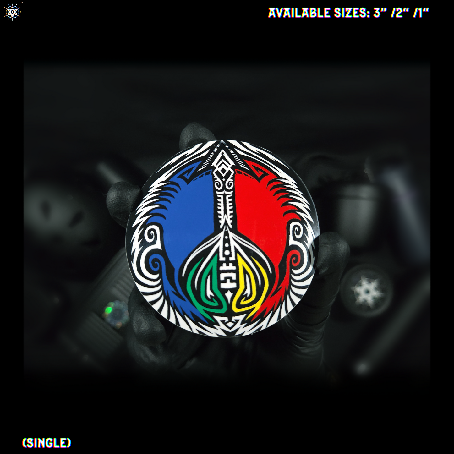 Image if a hand holding a peace symbol sticker with colorful (red, blue, black, yellow, green and white) tribal design on a blurred background.