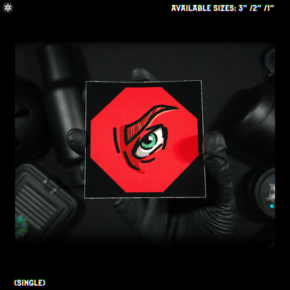 Hand holding a red square with an eye design against a dark background
