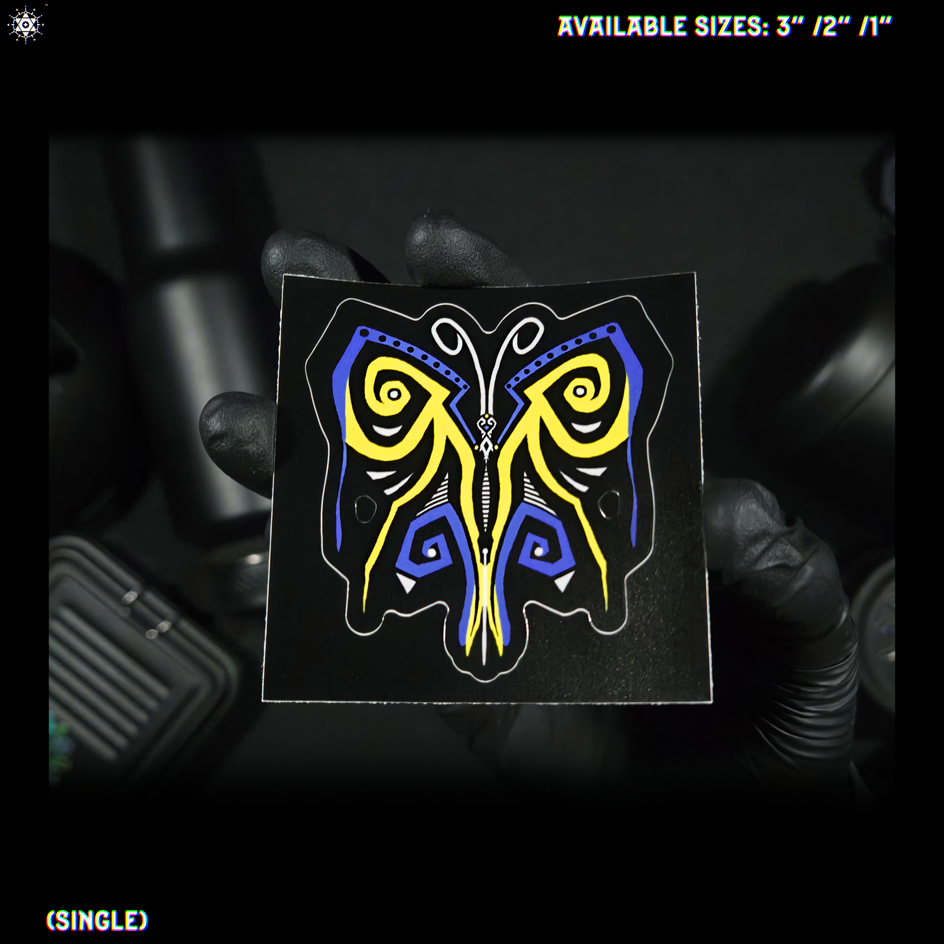 Video depicting a had holding and showing a blue, black, yellow and white, butterfly shaped sticker.